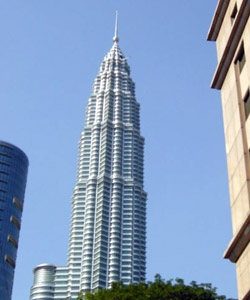 One of the twin towers, standing tall in the clear blue sky.